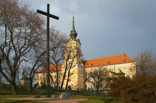Krzyż i tablica na głazie  przed zamkiem upamiętnające ofiary komunizmu